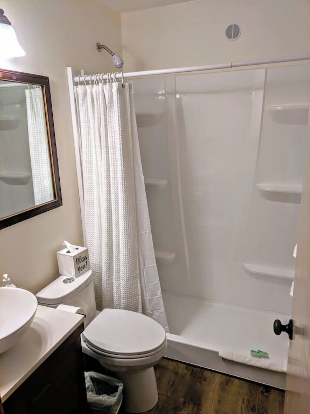 A bathroom with a toilet, sink, and shower area.