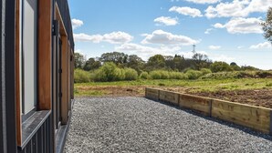 A modern building with a gravel pathway leading to a wooden deck.