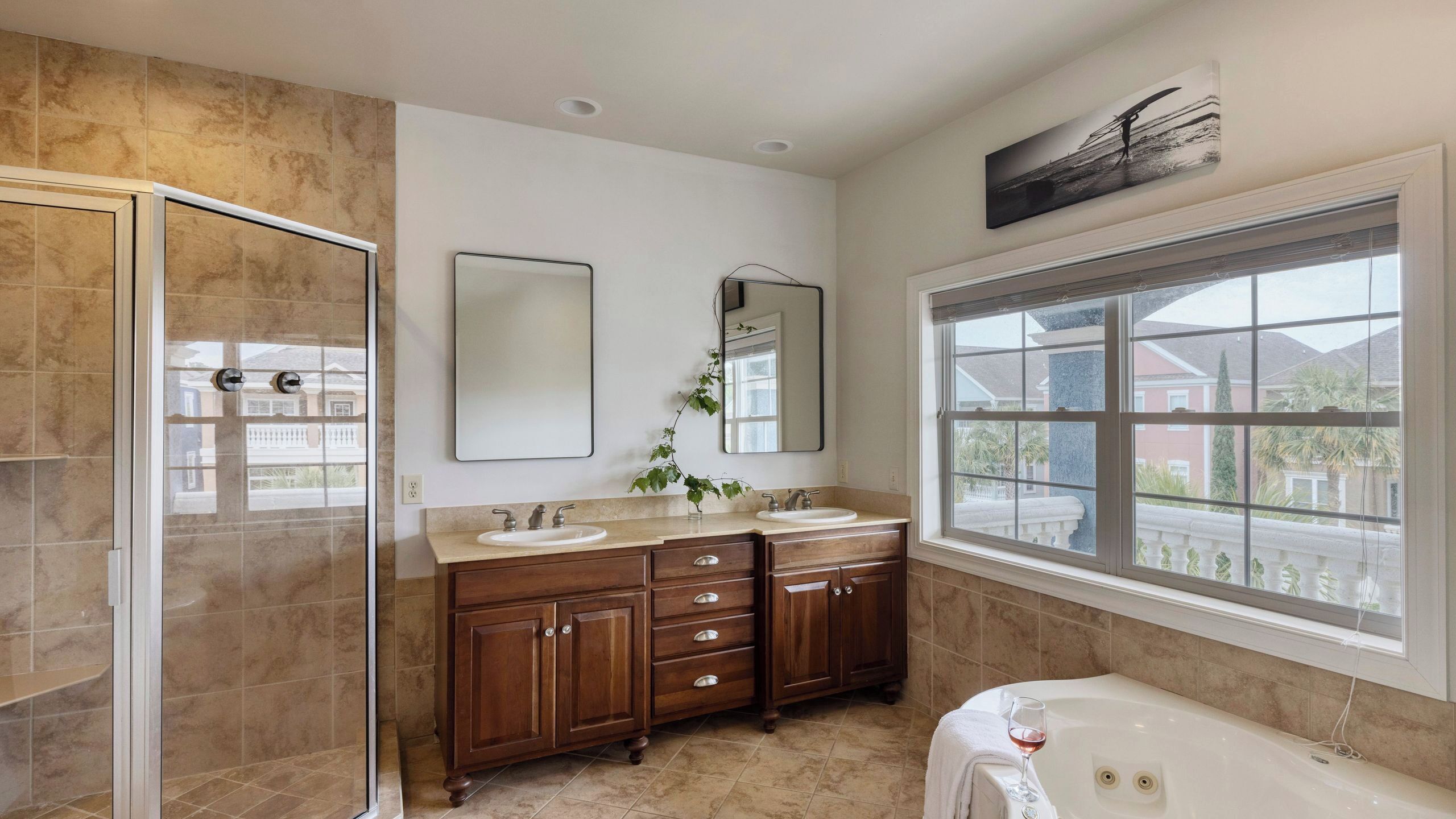 A bathroom with a walk-in shower, double sinks, a large mirror, and a bathtub.