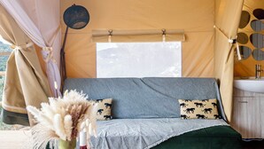 A cozy tent with a bed, a hanging basket, and a sink. - Glamping Chania - Secluded Oasis Among the Trees (Tsivaras)