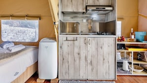 A compact kitchen with wooden cabinets, a stainless steel sink, and a compact refrigerator. - Glamping Chania - Secluded Oasis Among the Trees (Tsivaras)