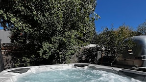A hot tub with a control panel, surrounded by trees and a clear blue sky. - ASPEN GROVE / Fernie / Hot Tub/ Walk Downtown (Fernie)