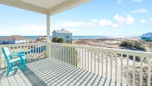 A wooden deck with a white railing overlooking a beach with houses in the background. - 🏖️ Snowbird Beachfront Paradise-Incredible Views🏝️Lotsa Sand C (Gulf Shores)