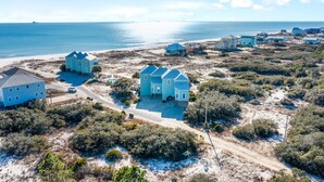 A coastal area with multiple houses, some with blue roofs, surrounded by vegetation and a beach. - 🏖️ Snowbird Beachfront Paradise-Incredible Views🏝️Lotsa Sand C (Gulf Shores)