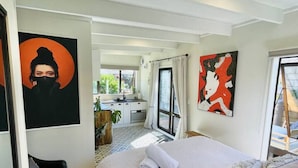 Habitación de hotel con una cama grande, un escritorio y vistas al exterior.