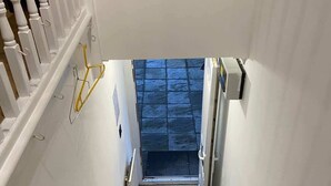 A carpeted staircase with a handrail, a door at the top, and a wall-mounted light fixture. - Charming Escape: 2BR Home with Parking (Aveley)