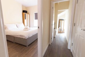 Un dormitorio con cama, armario y espejo.