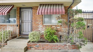 Una casa in mattoni con una porta d'ingresso, un piccolo portico e un cancello in metallo.