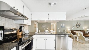 Una cocina moderna con armarios blancos, electrodomésticos de acero inoxidable y una isla central.