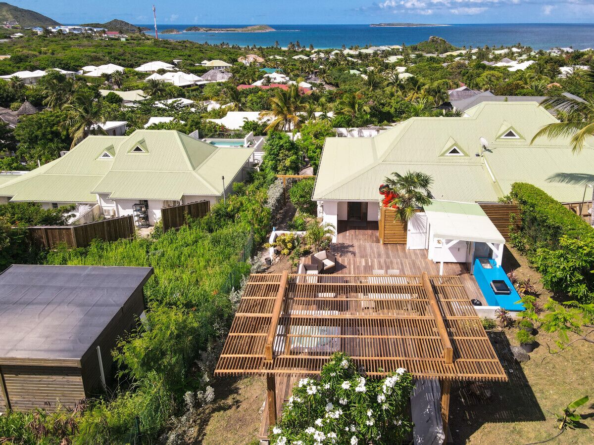 A residential area with houses, a wooden deck, and a swimming pool.