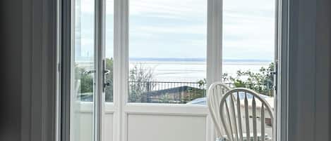 A room with a view of a body of water through large windows.