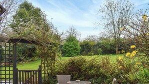 An outdoor patio with wicker furniture and a pergola. - Lower Axford Cottage (Callington)