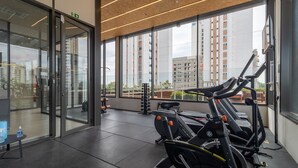 A gym with exercise equipment, large windows, and a view of buildings. - OF 611b in S o Paulo (São Paulo)