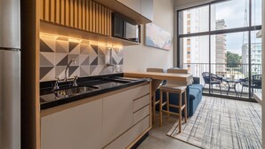 A modern kitchen with a large island, built-in appliances, and a dining area with a view of the city. - OF 611b in S o Paulo (São Paulo)