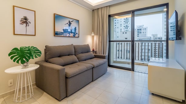 A modern living room with a sofa, a small table with a plant, and two framed pictures on the wall. - Ai78-902 in S o Paulo (São Paulo)