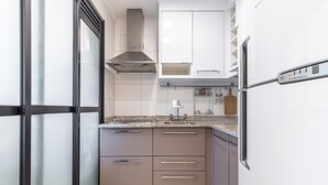 A compact kitchen with white cabinets, a stainless steel range hood, and a built-in oven. - Ai78-902 in S o Paulo (São Paulo)