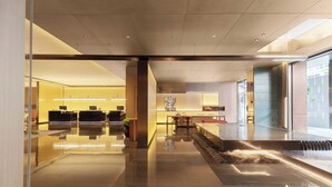 Um hall moderno com piso refletivo, balcão de recepção, área de estar e um elemento de água.