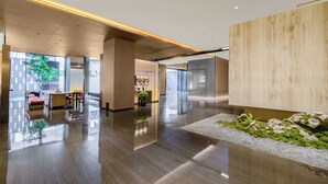 A modern lobby with a polished floor, seating area, and a reception desk. - Holiday Inn Express Hangzhou Jiangnan by IHG (Hangzhou)