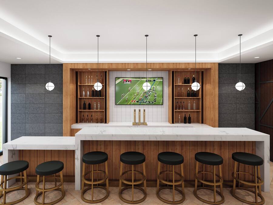 Una cocina moderna con una isla grande, taburetes de bar y un televisor mostrando un partido de fútbol.