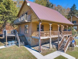 A log cabin with a porch, a staircase, and a satellite dish. - Beautiful 6 Bedroom Cabin with Hot Tub and a Lakeview of Dale Hollow Lake #12 (Byrdstown)