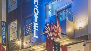 Un hôtel doté d’une façade moderne, de grandes fenêtres en verre et de plusieurs drapeaux exposés à l’extérieur.