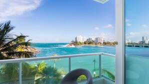 A balcony with a view of the ocean and cityscape. - Oceanview Penthouse · Pool · Water Backup (San Juan)