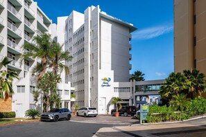 A modern hotel with a white facade, multiple balconies, and a sign indicating self-parked parking. - Designer Oceanview Penthouse & Pool - Condado (San Juan)