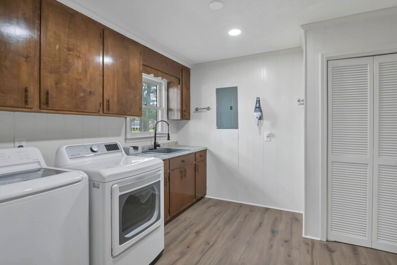 A laundry room with a washing machine, dryer, and a sink.