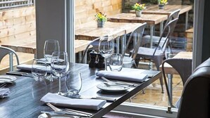 A dining area with tables set for two, clear glassware, and a view of the outdoor patio. - Ardgowan Hotel (St. Andrews)