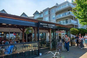 Una cafetería llamada Muddy Waters con terraza y un cartel que indica que está abierta.