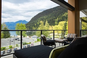 A balcony with a view of a parking lot and mountains.