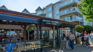 A coffee shop named Muddy Waters with outdoor seating and a view of residential buildings in the background.