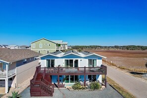 A beachfront property with a covered patio, a small pool, and a view of the ocean.