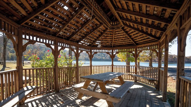 A wooden gazebo with a picnic table, surrounded by a wooden deck and railings, overlooking a lake. - Breathtaking Lakeside 2-Bedroom Cabin on Beautiful Dale Hollow Lake #9! (Byrdstown)