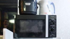 A microwave with a control panel, a black coffee maker, and a white mug on top. - アクセス&コスパ最高!徒歩 本町駅5分! 広々デザイナーズ1LDK、最大6人!902 (大阪市)