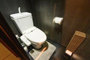 A modern bathroom with a white toilet, a hand dryer, and a paper towel dispenser. - アクセス&コスパ最高!徒歩 本町駅5分! 広々デザイナーズ1LDK、最大6人!902 (大阪市)