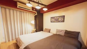 A hotel room with a large bed, a ceiling fan, an air conditioning unit, a floor lamp, and a painting on the wall. - アクセス&コスパ最高!徒歩 本町駅5分! 広々デザイナーズ1LDK、最大6人!902 (大阪市)