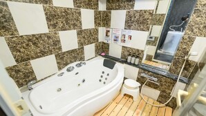 Un baño con una bañera independiente, un inodoro pequeño y un espejo.