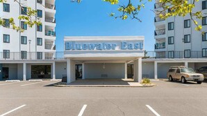 Hotel Bluewater East, con entrada despejada, estacionamiento y edificios adyacentes.
