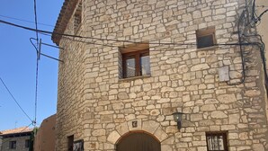 A stone building with a wooden door and multiple windows.