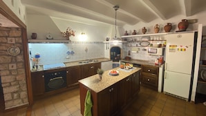 A kitchen with a central island, a built-in oven, and a refrigerator.