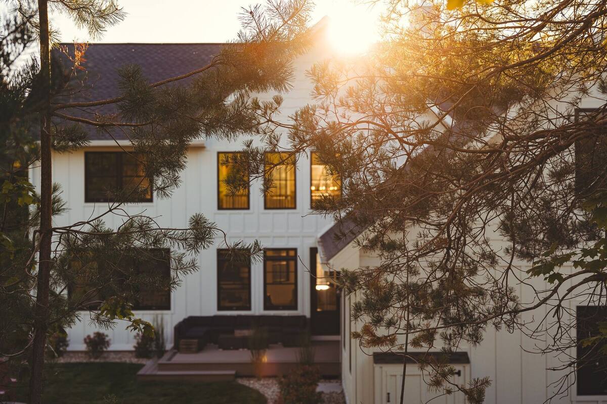A two-story house with a front porch, a visible staircase, and a well-maintained lawn.