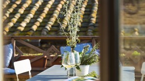 A table with a potted plant and wine glasses, set against a backdrop of wine bottles. - Zafferano Rooftop Terrace Tower House (San Gimignano)