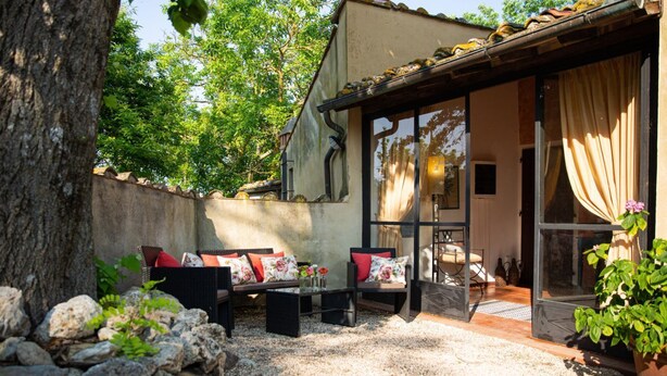 Un espace patio avec des sièges extérieurs, une pergola et une vue sur le jardin.