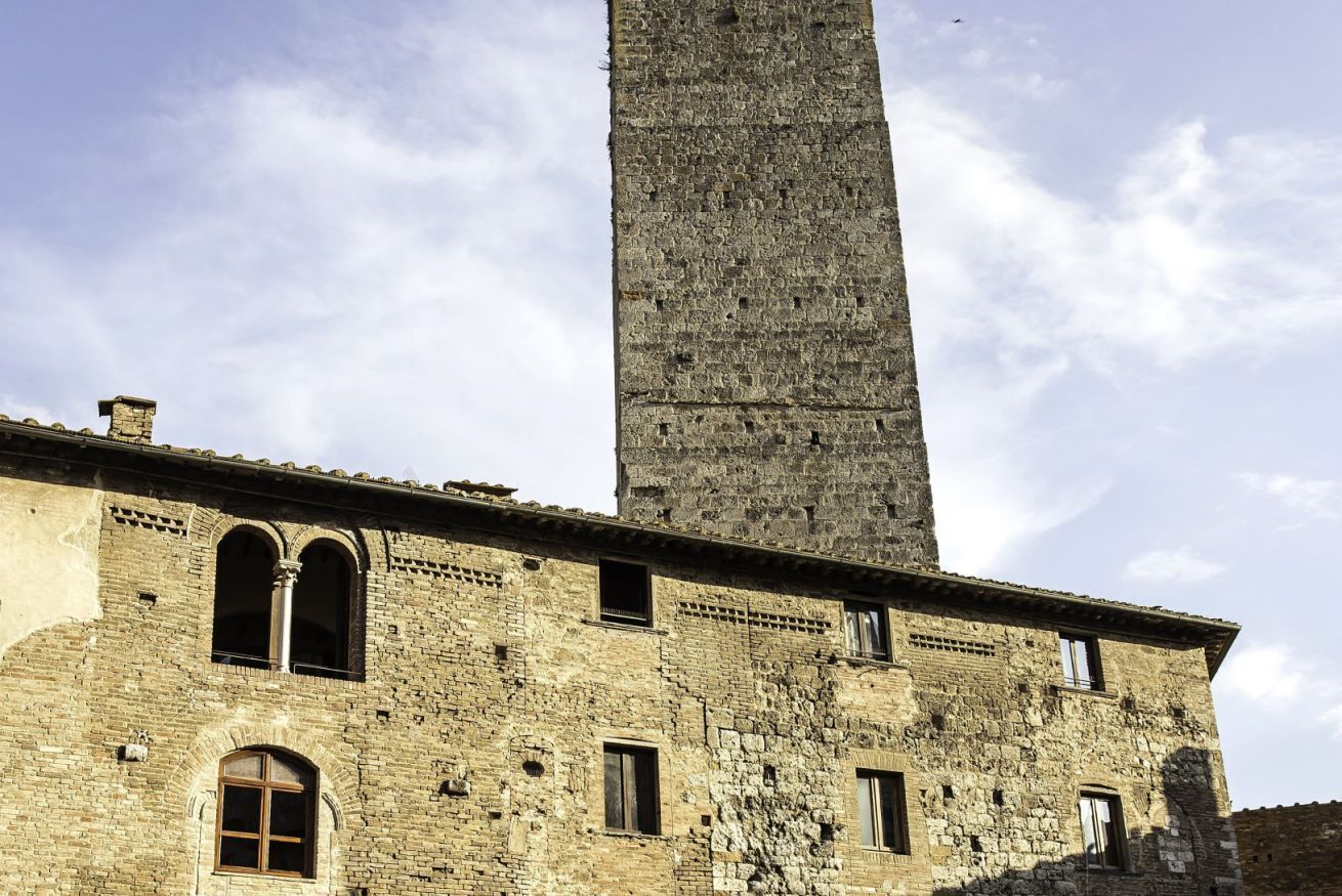 Un edificio histórico con una torre alta y esbelta y varias ventanas de arco.
