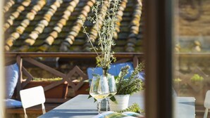 Une table avec une plante en pot, des verres à vin et un magazine ouvert.