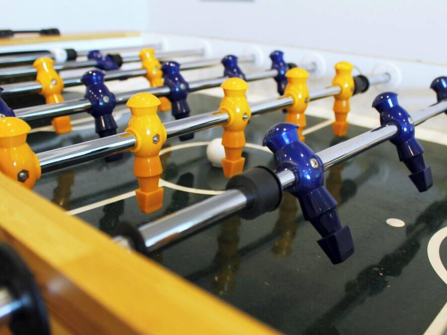 A foosball table with yellow and blue player figures.