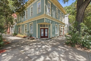 A two-story building with a red door and multiple windows.