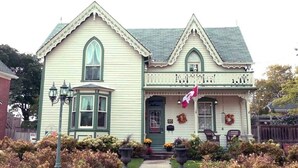 A Victorian-style house with a front porch, a mailbox, and a number '80' sign. - Bristow's Inn (Township of Woolwich)