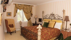 Un dormitorio con cama con dosel, una silla, una mesita de noche y una ventana con cortinas.